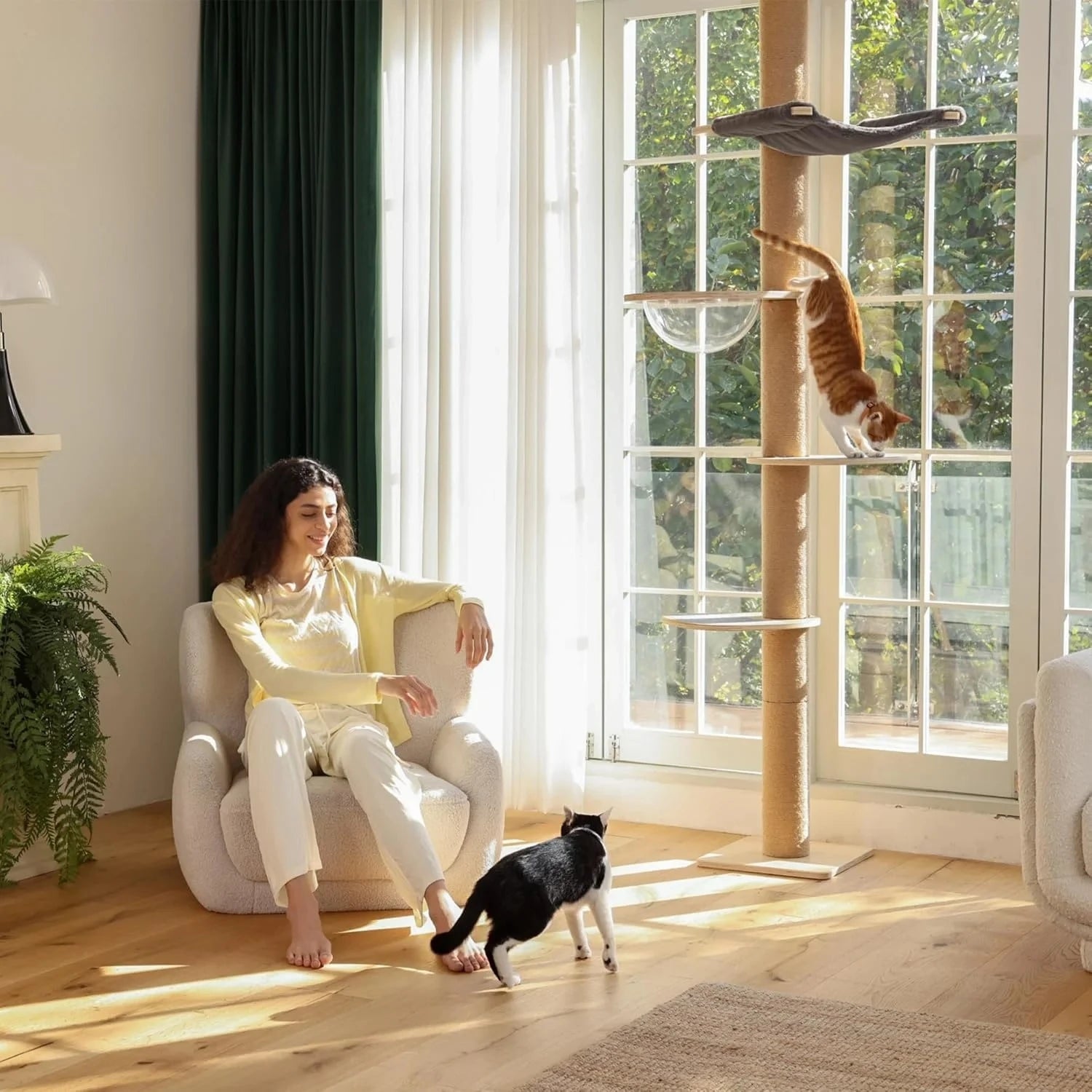 A large, luxurious cat tree made from sustainable wood, featuring climbing posts and toys that extend from floor to ceiling