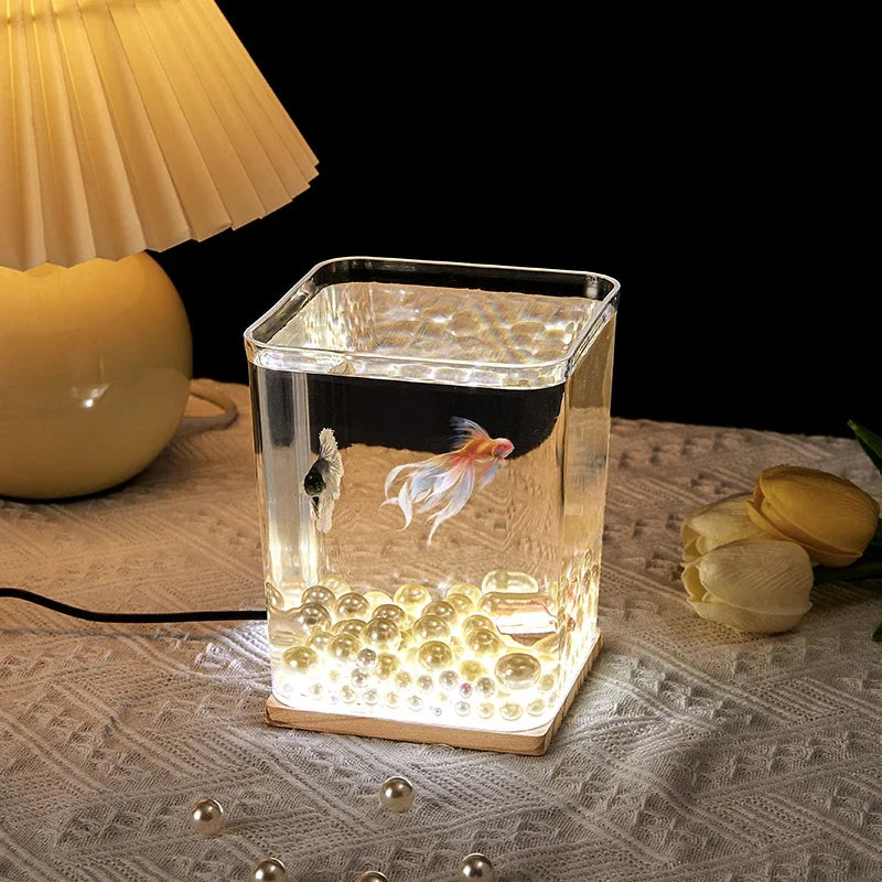 A small barrel-shaped fish tank with a built-in lighting system, a tabletop miniature landscape, and a mini aquarium s